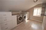 laundry room with storage space and clothes racks